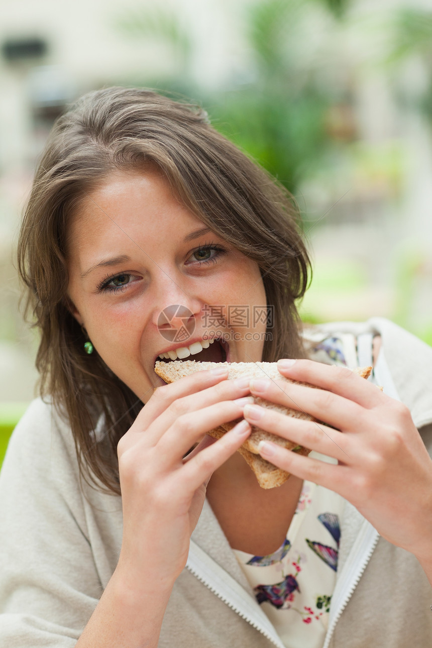 女学生在自助餐厅吃三明治的情况短发头发午休休息咖啡店午餐时间女性学校食堂图片