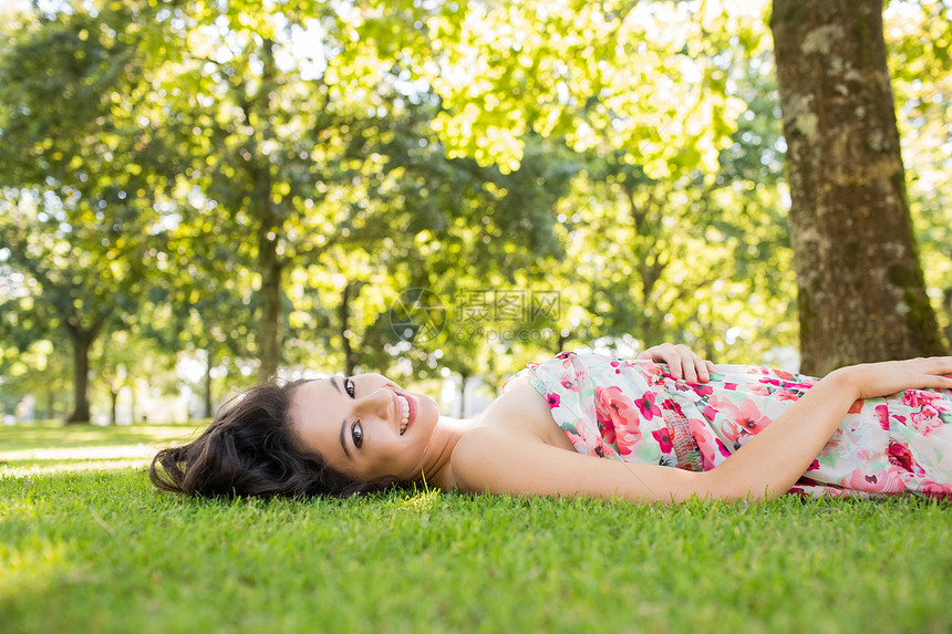 在草坪上躺着的 时尚美丽的黑发美女图片