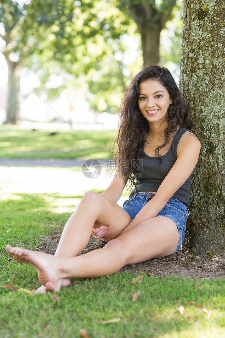 坐在树上坐着 面带笑容的黑发人图片