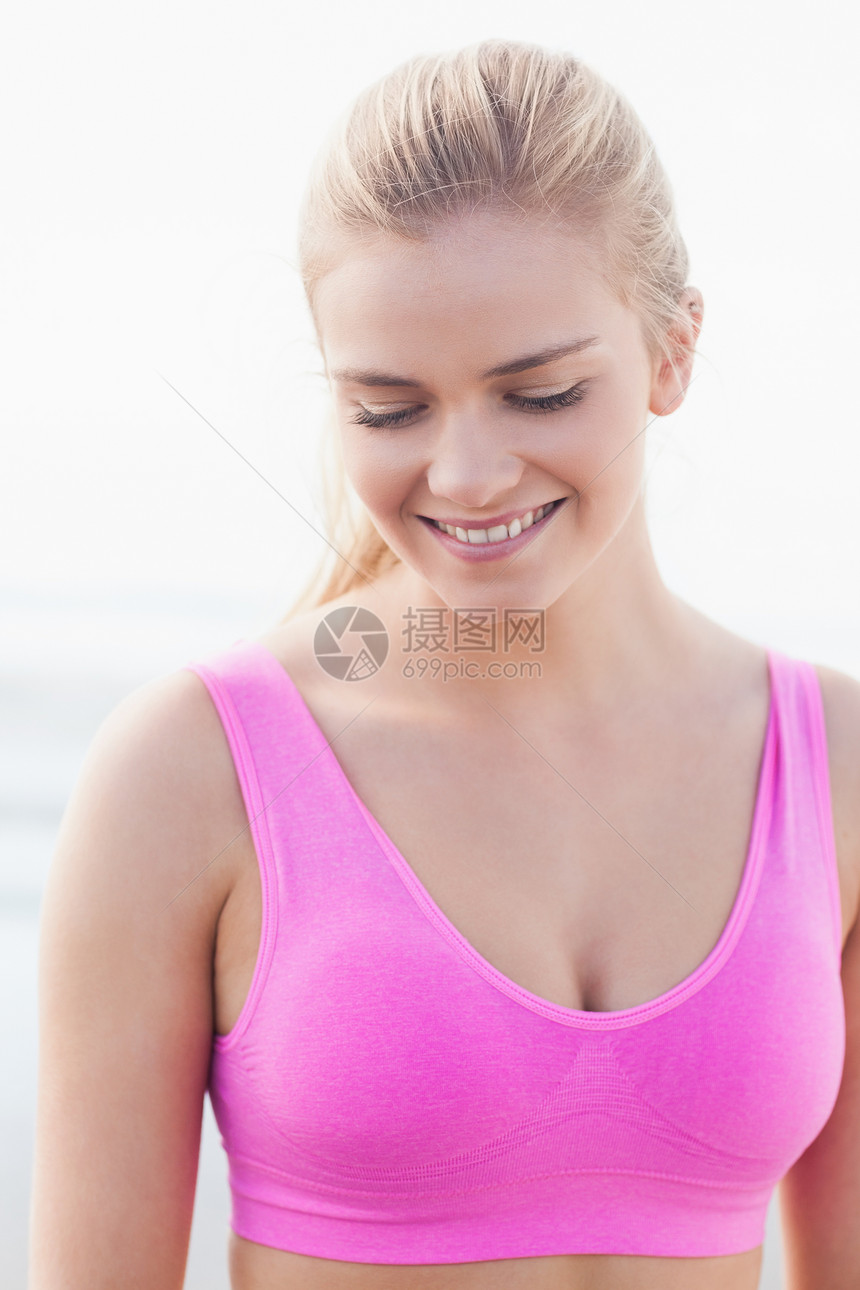 紧贴着一个微笑健康的女人向下看身体头发体力文胸晴天海滩运动服金发锻炼慢跑图片
