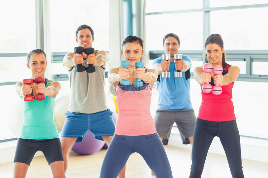 人们在健身房与教练一起举起哑铃的重量调子训练起重举重肌肉护理健身室女性闲暇力量图片