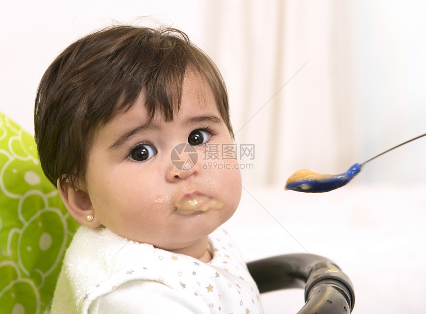 喂一个可爱可爱的女婴孩子父亲母性食物牙裔育儿营养妈妈眼睛爸爸图片