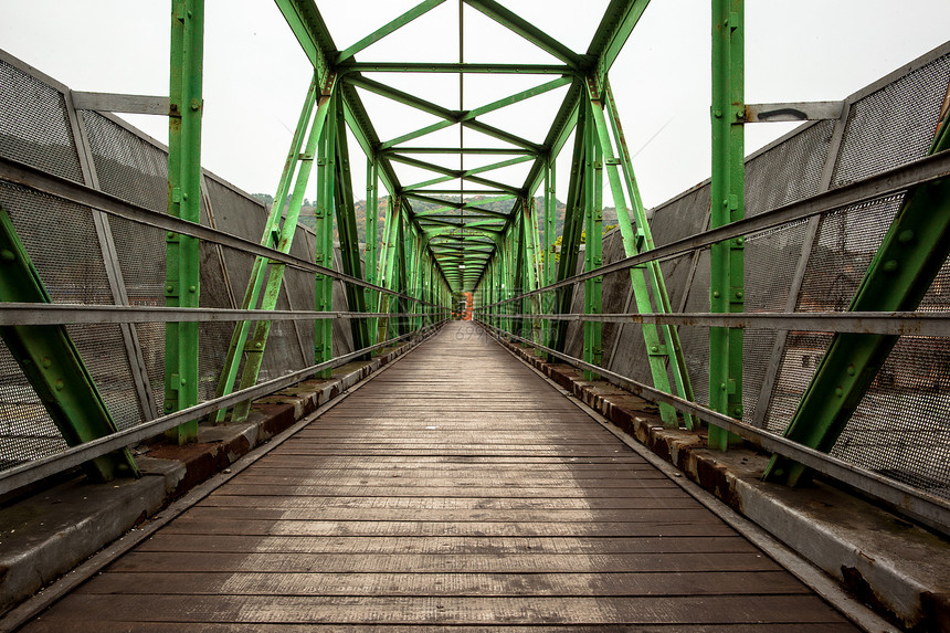 具有对称金属结构的足桥栏杆天桥道路铁路几何学工程天空建筑学木镶板途径图片