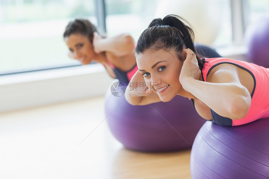 两名健身女子在健身球上锻炼的肖像图片