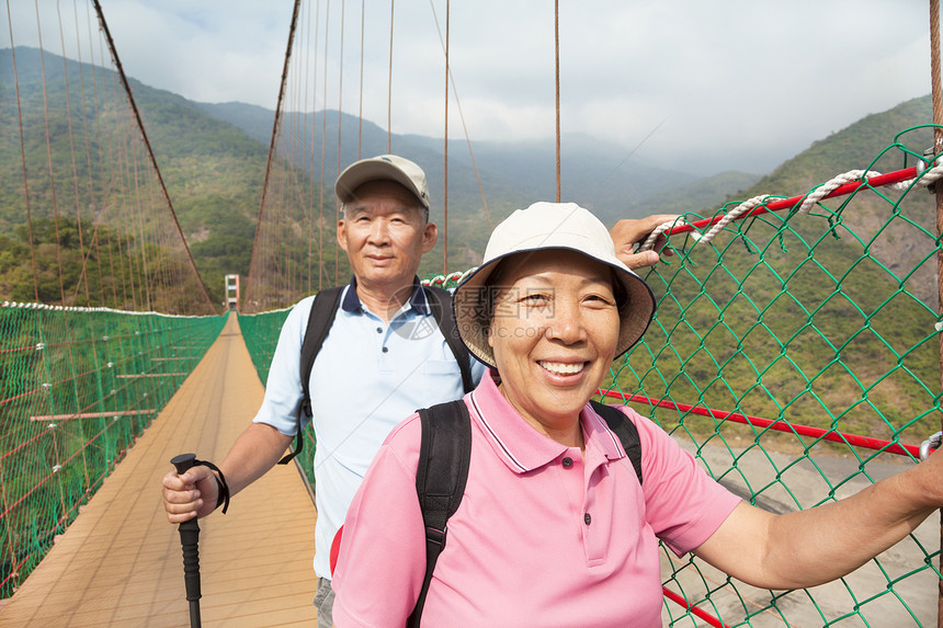 快乐的年长夫妇 在自然中走在桥上乐趣老年男人国家男性旅行森林闲暇家庭公园图片