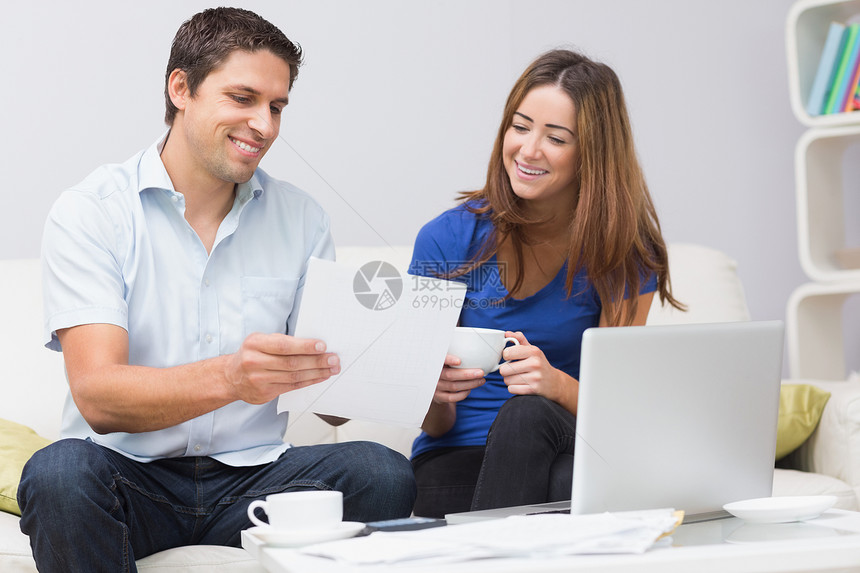 一对夫妇在家里网上支付他们的账单图片