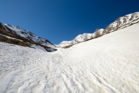 美出新高度高高度雪融化模式荒野气候蓝色山峰勘探运动阳光地区全景山脉背景
