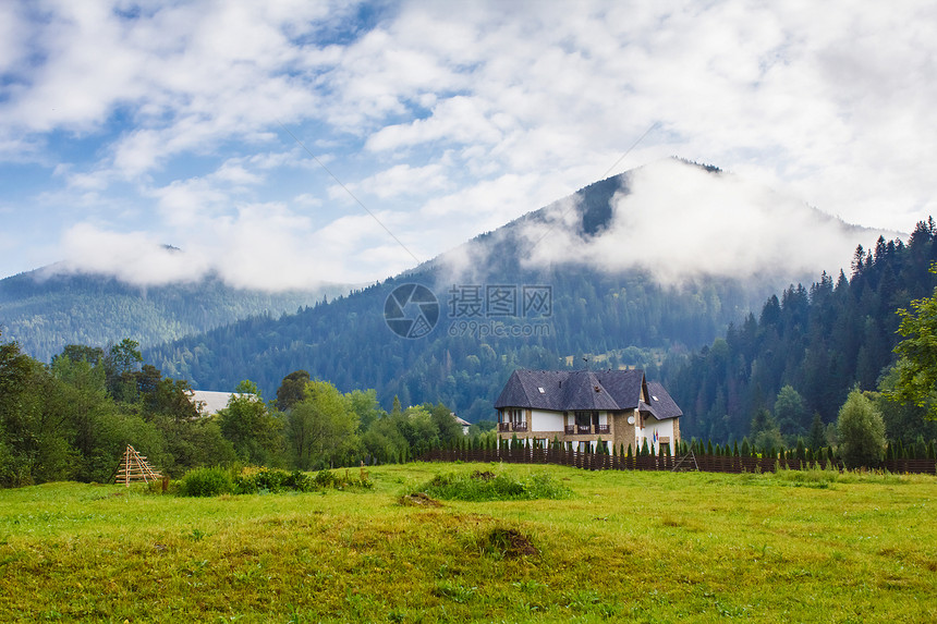 山之间有房屋空气乡村场地风景旅游奢华蓝色草地晴天小屋图片