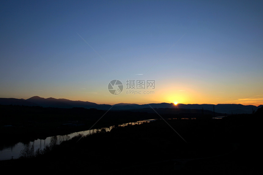 日落前的河流太阳天蓝色石头岩石风景森林远景季节地标山脉图片