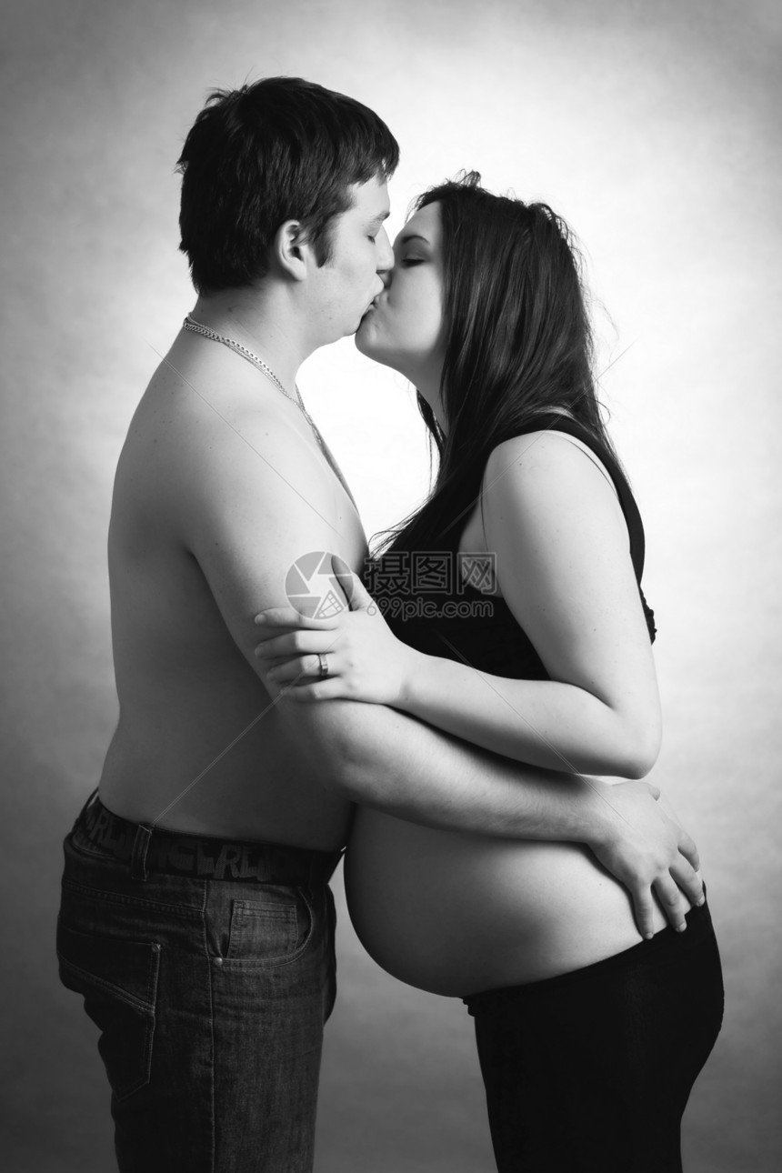 快乐的情侣 丈夫亲吻怀孕妇女肚子腹部男人男性婴儿夫妻喜悦女士工作室亲热图片