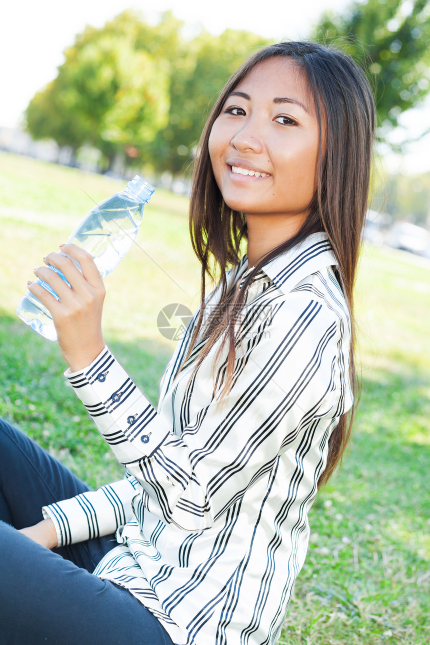 亚洲女孩在公园饮用水供应量图片