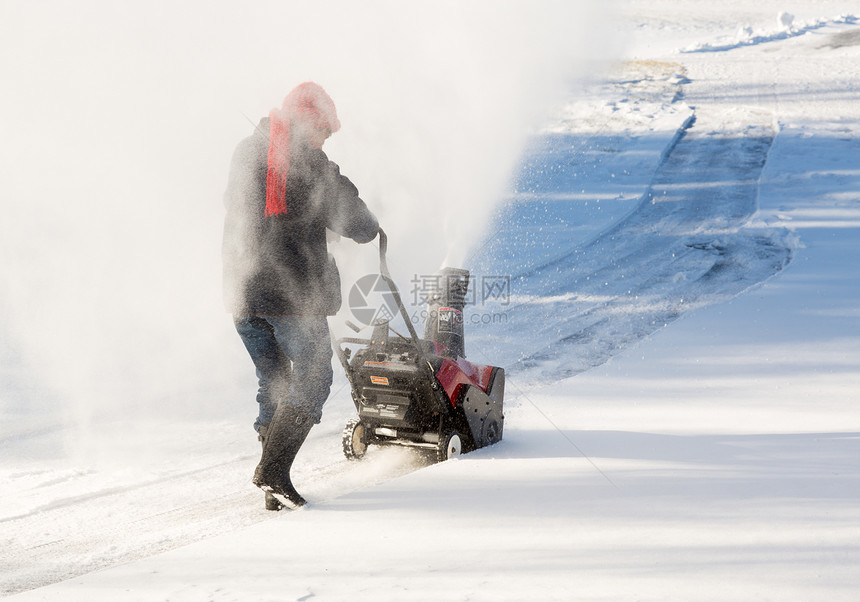 高级妇女与吹雪者清扫车天气住宅人行道退休工作机器投掷者车道打扫女士图片