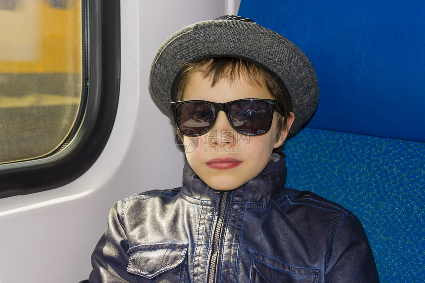 戴太阳眼镜的帅帅男孩坐火车乘客旅游运动童年青少年铁路运输速度记忆太阳镜图片