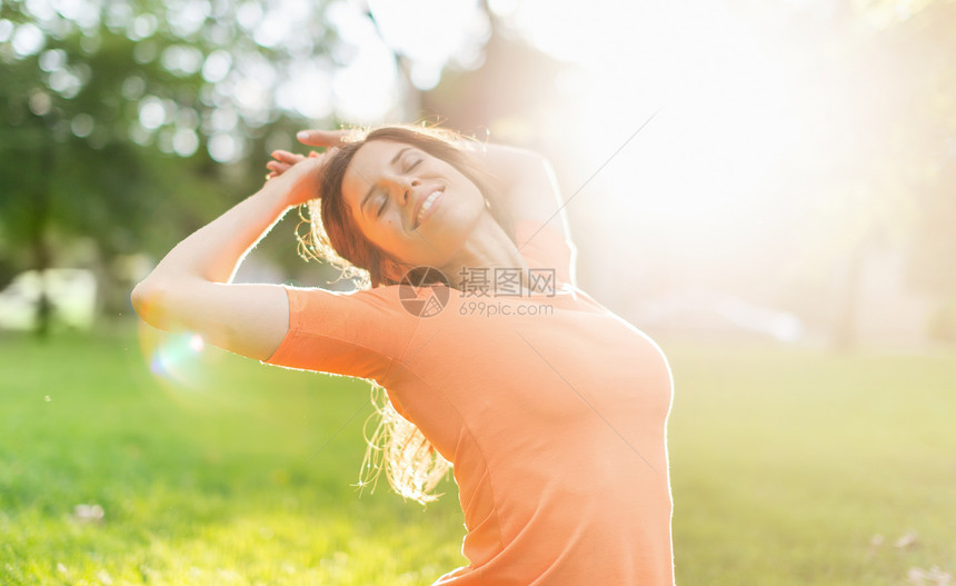 享受日落温暖的多族裔女孩练习庆典生活方式乐趣双臂太阳耀斑女士森林橙子混血儿图片