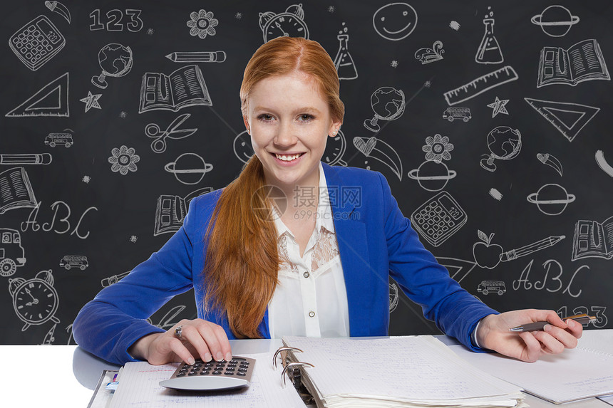 年轻女商务人士在计算和写纸上写的论文学校银行业商业微笑职业思维电脑会计桌子成功图片
