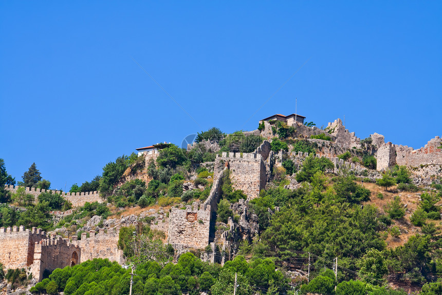 土耳其在艾伦亚的土耳其堡垒文化蓝色旅游爬坡旅行岩石游客地标房子假期图片