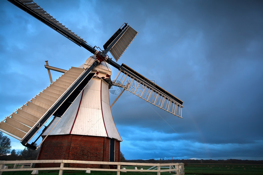 日落光下的白色荷兰风车图片