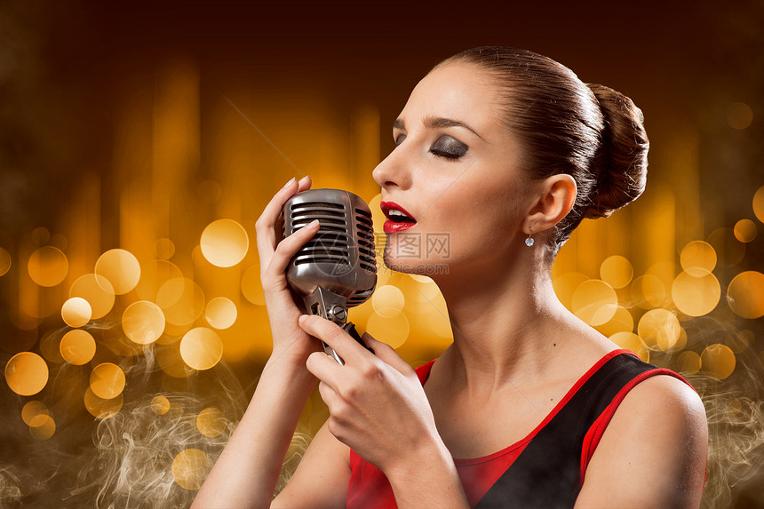 具有麦克风的有吸引力的女性歌手演员女士享受俱乐部夜店唱歌流行音乐岩石星星多样性图片