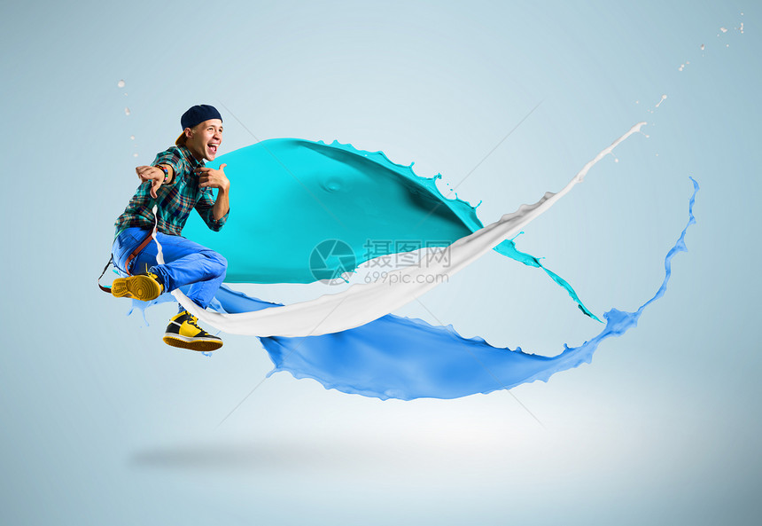 年轻男舞蹈者随涂料喷洒跳跃男人杂技男性蓝色青少年身体冒充成人运动艺术图片