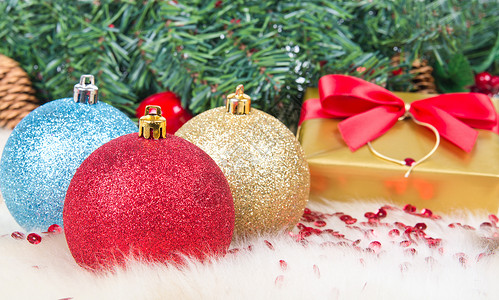 圣诞礼物和舞会毛皮绿色展示松树黄色礼物红色背景图片