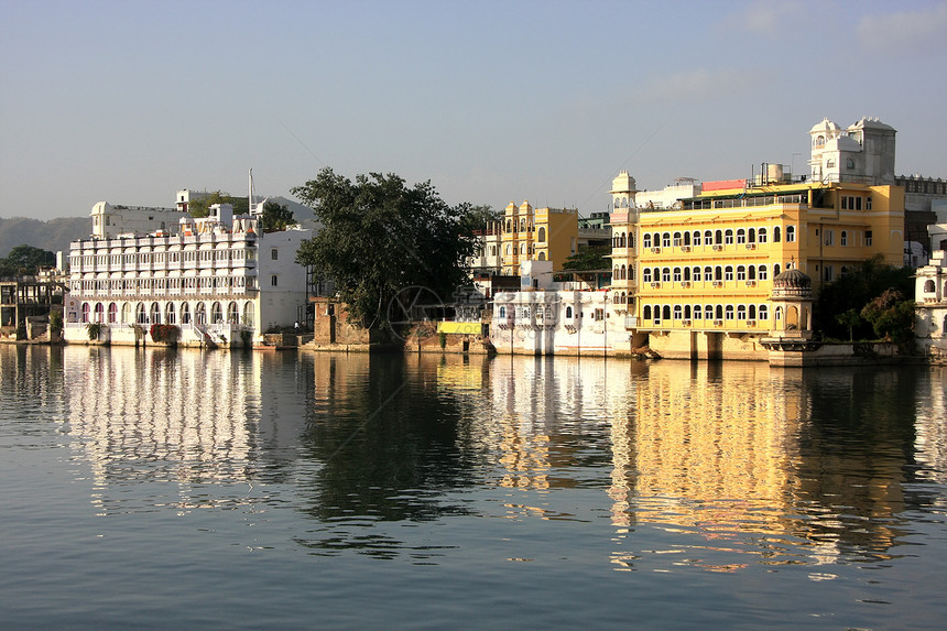 印度拉贾斯坦邦皮乔拉湖和乌代普尔市城市历史蓝色反射建筑学孔雀全景天空建筑黄色图片