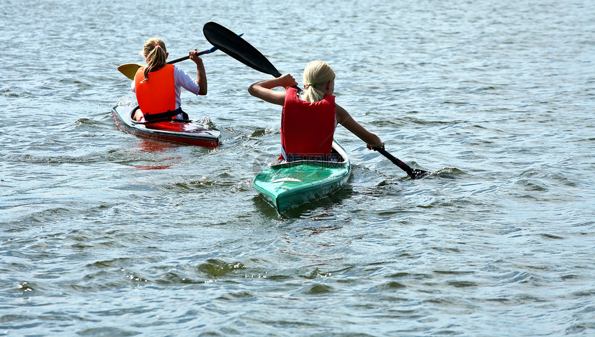 在湖边登山口的皮艇上的年轻人太阳乐趣孩子们游戏金发竞赛喜悦独木舟运动地平线图片