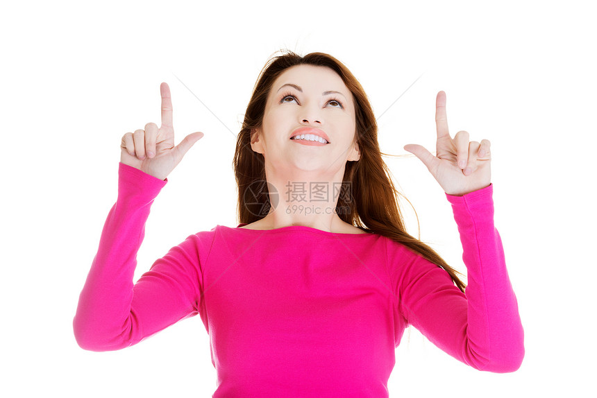 快乐 兴奋的女人指着复制空间手臂手势黑发手指喜悦产品粉色白色微笑广告图片