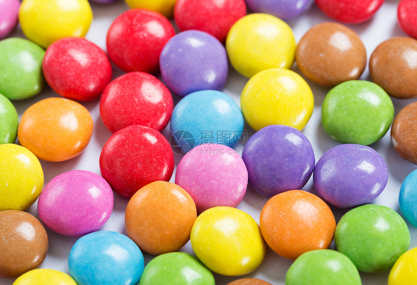 丰富多彩的糖果小吃巧克力涂层蓝色黄色墙纸粉色按钮蜜饯纽扣形图片