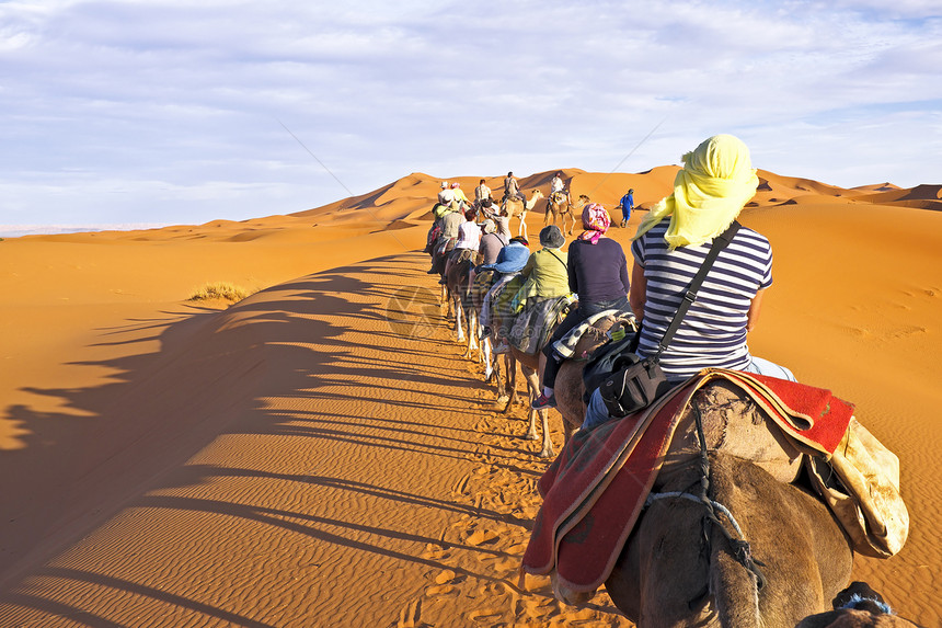 骆驼大篷车穿过撒哈拉沙漠的沙丘太阳动物寂寞驼峰旅行晴天孤独游客单峰哺乳动物图片