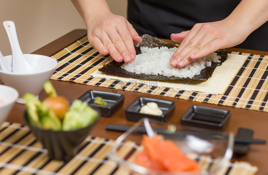 女厨师用大米填满日本寿司卷大豆美食螃蟹黄瓜营养食物海藻女士饮食女孩图片