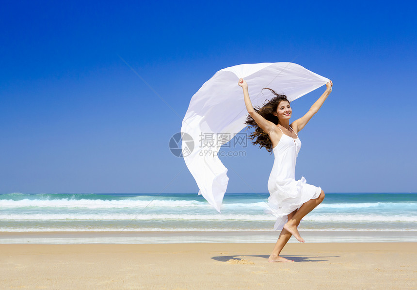 带着白围巾跳跃女孩喜悦海滩假期享受织物女性晴天跑步幸福图片