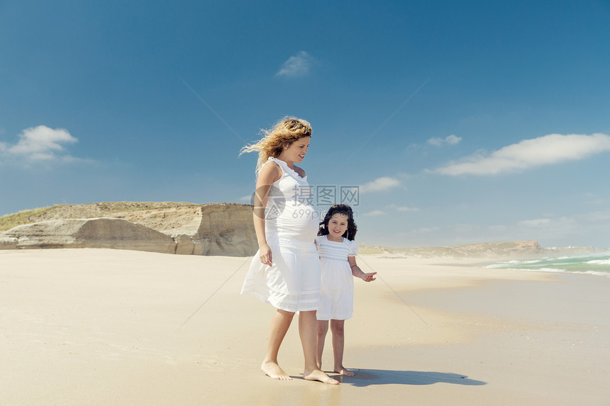 孕妇和她女儿在沙滩上的海滩上情感成人女性孩子们乐趣母亲童年母性假期天空图片