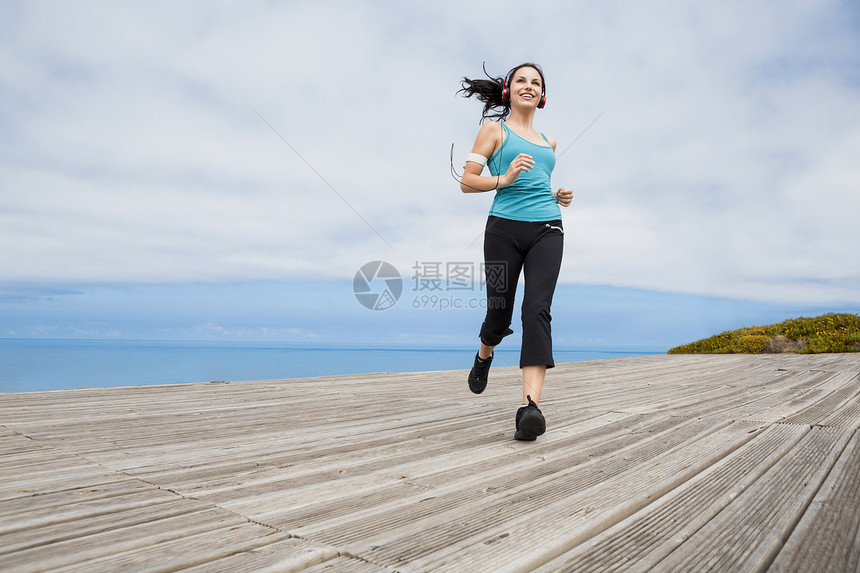 慢跑耳机运动装运动慢跑者速度活动海滩女性成人天空图片