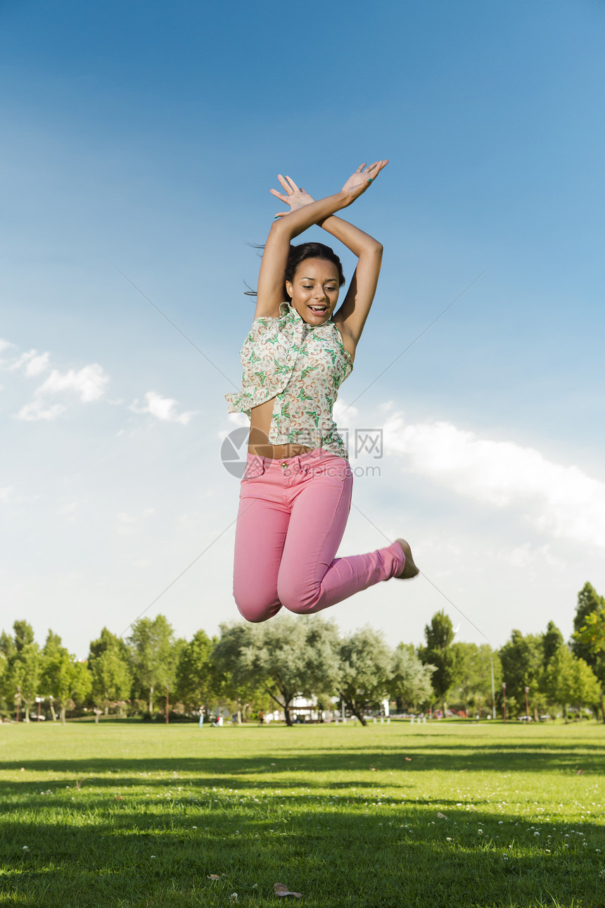 美丽的非洲裔美国女女性跳跃空气乐趣爆炸自由森林幸福女孩成人公园黑发图片