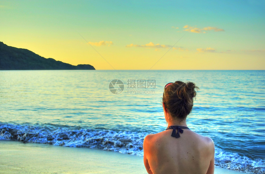 女人看着海滩的日落海浪稻草气候旅游游客天空热带蓝色时段肩膀图片