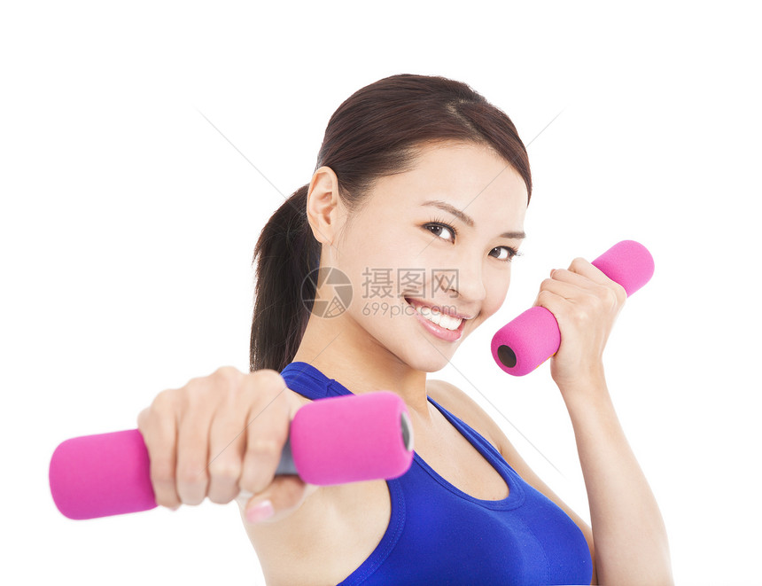 年轻女人用哑铃在她手里打工身体工作室女士运动装健身房运动权重重量女性力量图片