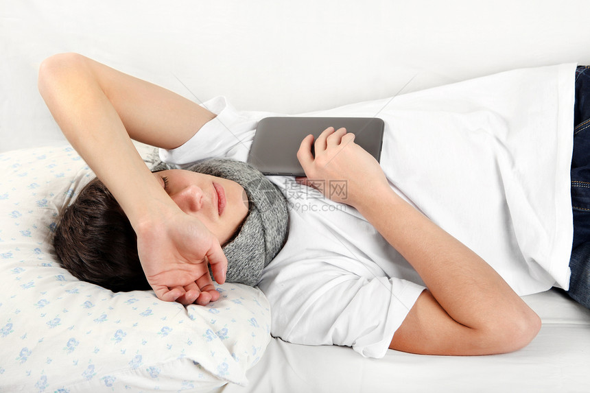 年轻人用平板电脑睡觉男性男人睡眠轨枕互联网沙发说谎枕头网络围巾图片