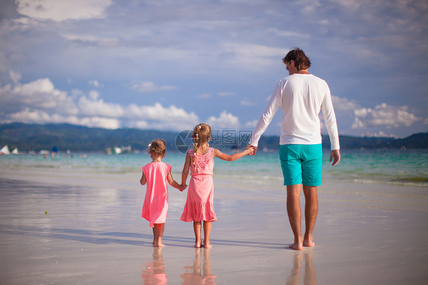 父亲和两个女孩在热带白沙滩上行走的背影海岸假期男人女孩家庭幸福乐趣孩子享受海岸线图片