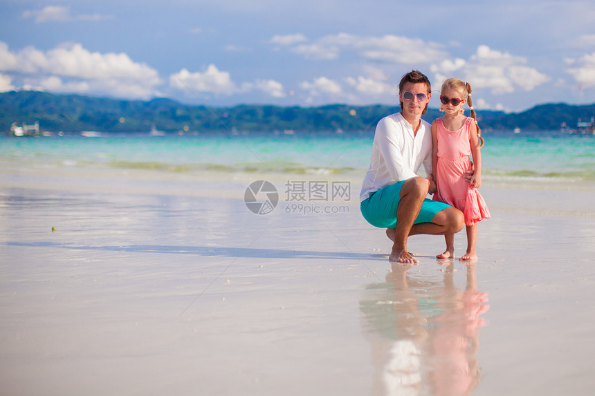 父亲和小女儿在白沙滩上放松海岸乐趣孩子情调家庭爸爸海洋海滩幸福异国图片