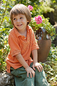 在玫瑰花园的小男孩背景图片