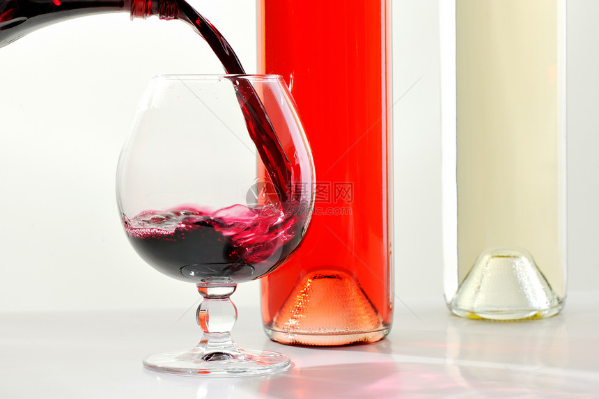装满葡萄酒和香肠瓶子的玻璃杯图片