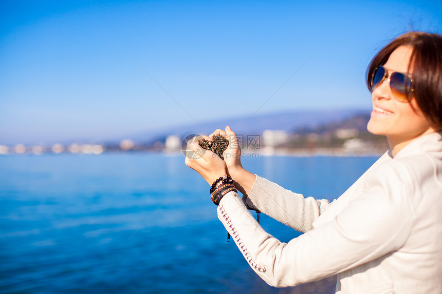 手握着小石头的女子 形成心形形状背景 海海异国情感女士身体女孩手指海洋女性珠宝手镯图片