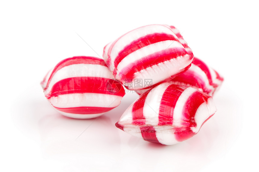 白色的彩色糖果被隔离在白色上款待食物条纹硬糖图片
