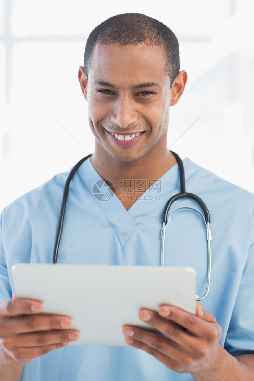 拥有数码平板电脑的英俊快乐医生图片