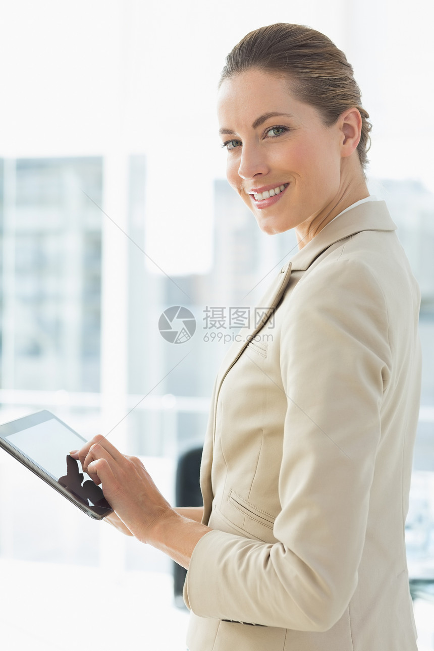 办公室使用数字平板电脑的漂亮女商务人士人士职场头发触摸屏套装女士滚动药片商务屏幕图片