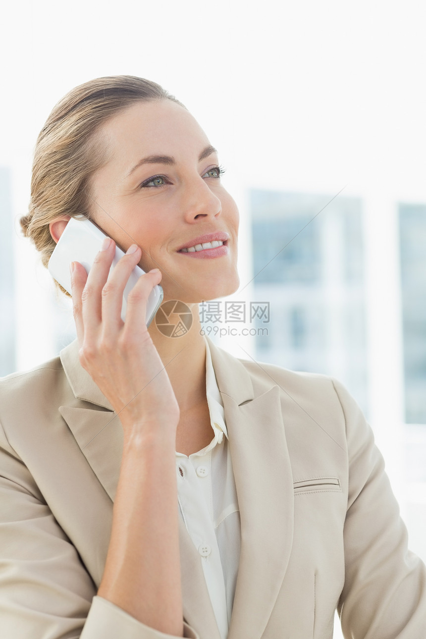 使用移动电话的美丽女商业妇女办公室套装拨号女性沟通微笑女士职场呼唤商务图片