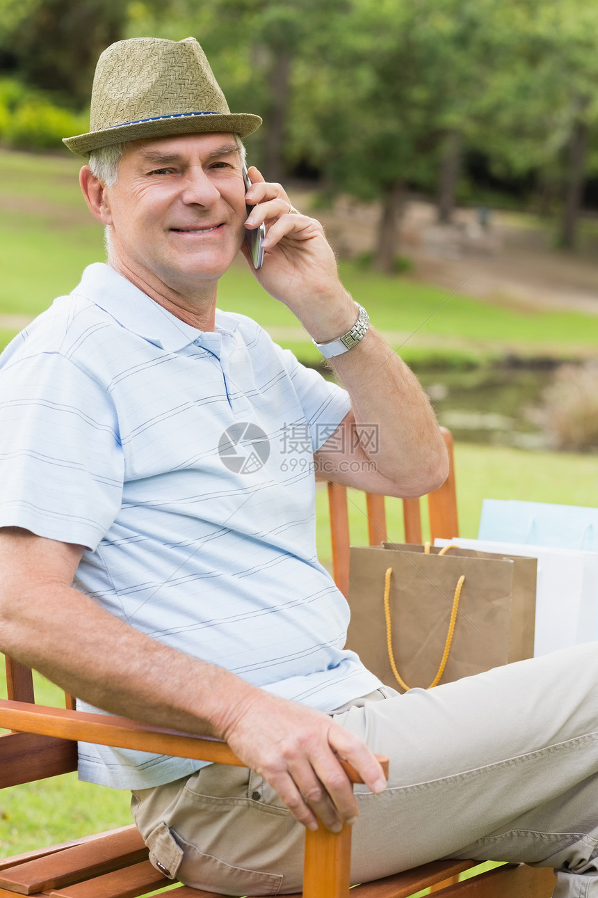 休闲老人在公园使用手机的业士图片
