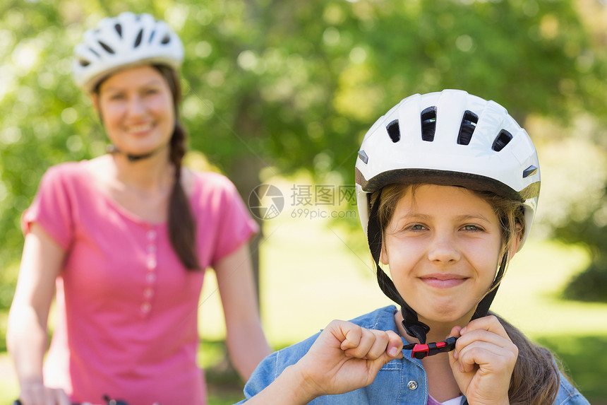 与女儿一起微笑的女人骑自行车女士成人乐趣母亲农村头盔安全女孩调整女性图片