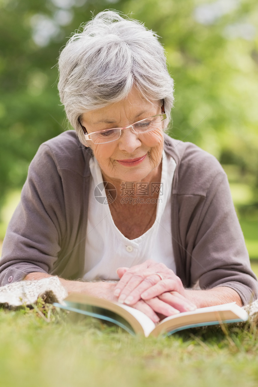 在公园看书的年长妇女退休成人女士女性绿地阅读树木微笑人员知识分子图片