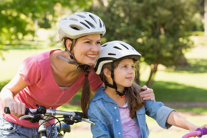 与女儿一起微笑的女人骑自行车享受女性公园孩子家庭成人母亲女士家长头盔图片